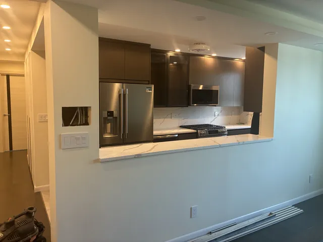 Renovated kitchen pass-through with dark cabinetry