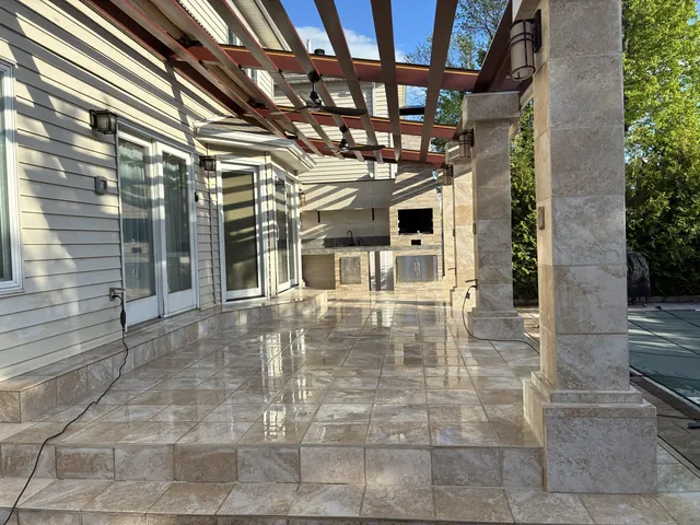 Tiled patio with stone columns and a pergola