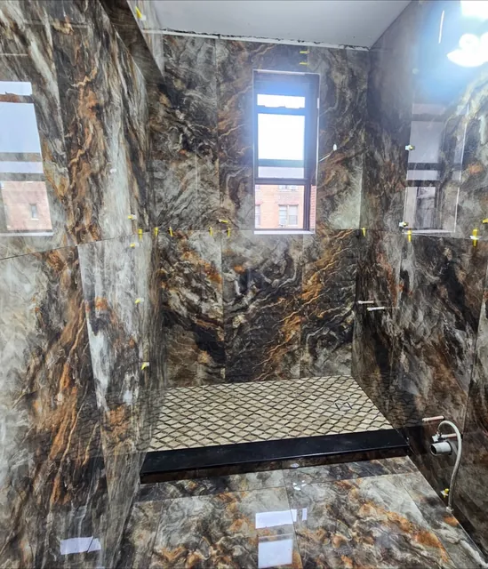 Shower in dramatic gold-veined tile